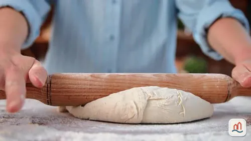 Pâte à tarte étalée sur un plan de travail fariné